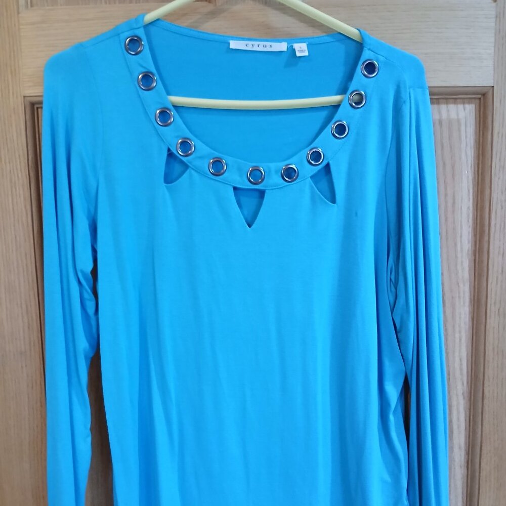 Long sleeved, teal blue shirt with cutout grommet neckline detail.